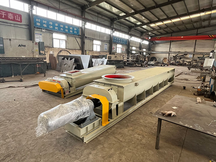 Two Dahan industrial screw conveyors wrapped in protective plastic, ready for overseas shipping