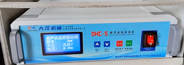 Close-up of the Dahan Machinery DHC-5 ultrasonic power system control panel for vibrating screens, showing the digital screen displaying "频率: 38K" (Frequency: 38K) and "电流: 0.39A" (Current: 0.39A) under continuous mode.