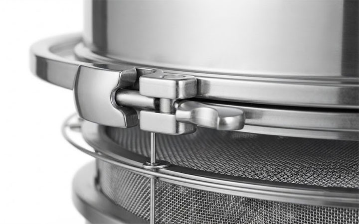 Close-up of a hygienic stainless steel quick-release clamp and fine mesh sieve on industrial equipment